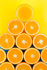 Cut halves of juicy orange on yellow blue background. Orange fruit, citrus minimal concept. Creative summer food minimalistic background. Top view, copy space