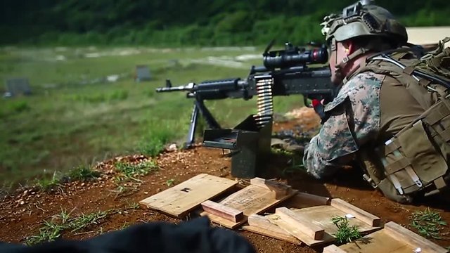 Soldier firing assault rifle in a target shooting range