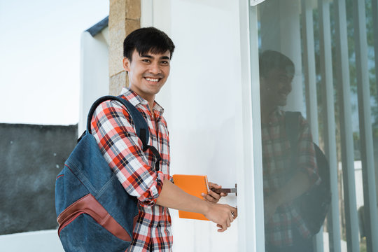 handsome male student lock his room before going to college campus