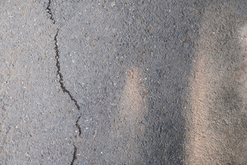 Asphalt with crack and shadows. Old gray road for background or texture. Asphalt as abstract background or backdrop with a copyspace