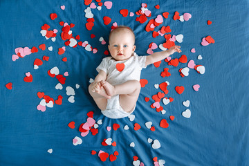 Cute adorable white Caucasian baby girl boy infant with blue eyes four months old lying on bed...