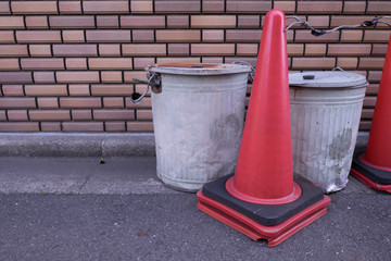 Garbage cans and cones by the wall