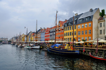 Panorama of north side of Nyhavn with colorful facades of old houses and old ships in the Old Town of Copenhagen, capital of Denmark.