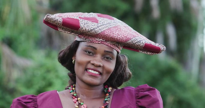 4K close-up portrait of pretty black Herero woman in Traditional Dress looking at the camera 