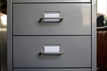 Filing cabinet with closed drawer, 2 white cards for write letter, Grey silver metal colour,...