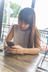 Asian girl using smartphone to surf the Internet