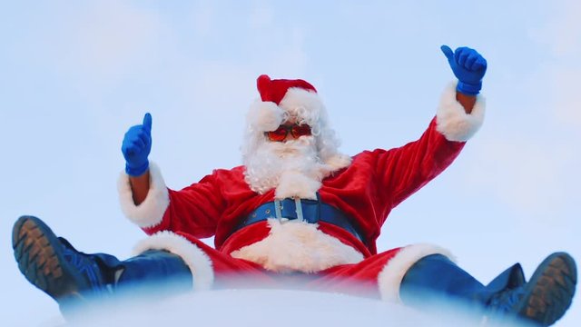 Adult male dressed as Santa Claus sitting atop an airplane dancing