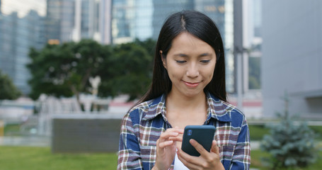 Woman use of mobile phone for text message in city