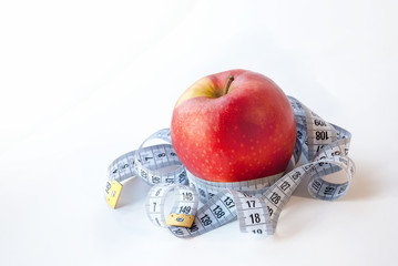Red Apple and measuring tape on white background. Diet concept