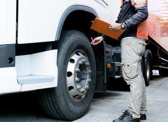 Truck Driver is Checking the Truck's Safety of Wheels and Tires. Semi TraIler Truck Inspection Maintenance Repair.	