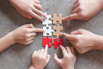 hands holding piece of jigsaw puzzle. teamwork concept