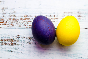 colorful violet and yellow easter eggs on wooden background