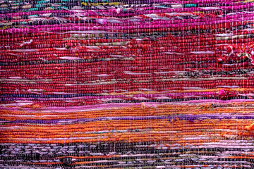 Cloth, typically produced by weaving or knitting textile fibers. Background and texture red old fabric. Closeup