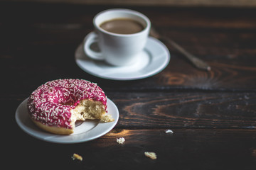 Bite a Pink donut with white sprinkle