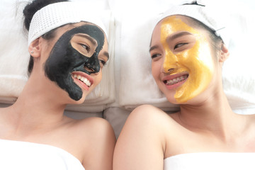 beautiful and healthy young woman relaxing with face massage skin care health black mask and gold mask at beauty spa salon