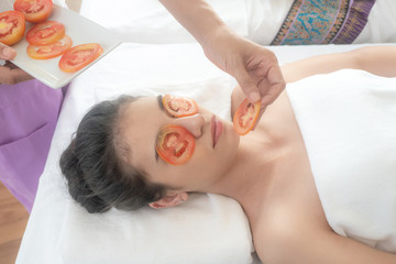Obraz na płótnie Canvas beautiful and healthy young woman relaxing with face massage skin care health tomato mask at beauty spa salon