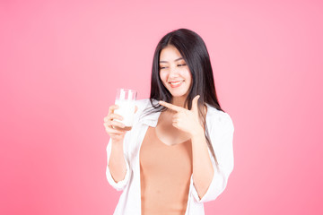 beauty woman Asian cute girl feel happy drinking milk for good health in the morning on pink background - lifestyle beauty woman