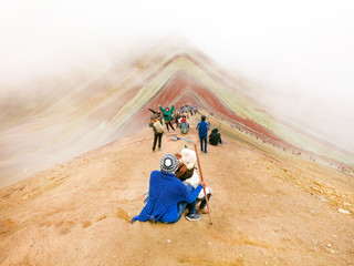 Couple of tourists sitting and looking towards the Rainbow Mountains, Cusco, Peru - obrazy, fototapety, plakaty