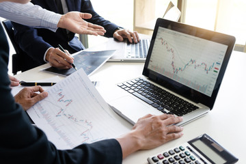 business man and woman sit at ther table looking at computer laptop