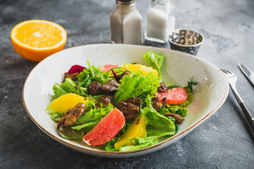 Tasty salad with citrus, lettuce and chicken liver