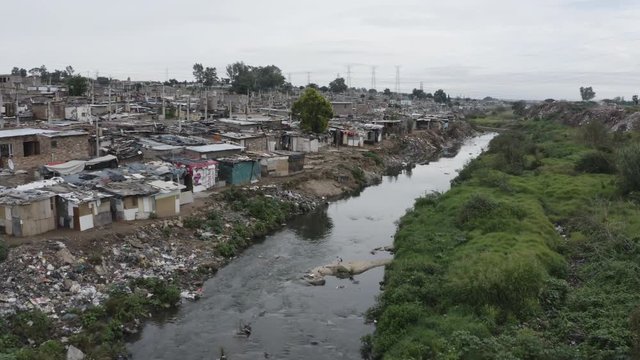 4K aerial close-up view of slums or squatter camp along the Jukskei river in the Alexandra township, South Africa 