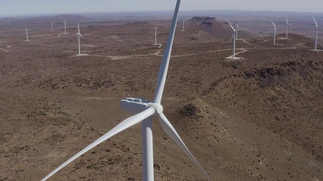 4K aerial close-up zoom out view of a wind turbine not turning, which causes a major problem for generation of energy