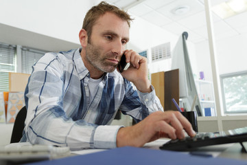 businessman talking by phone in office