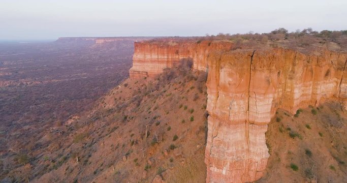 4K aerial view flying close to the beautiful red sandstone Chilojo cliffs at sunset, Gonarezhou National Park, Zimbabwe