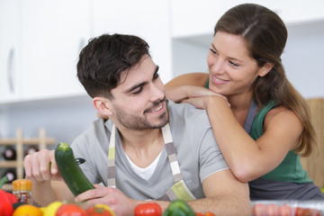 Obraz na płótnie Canvas man and woman cooking vegetarian dish together