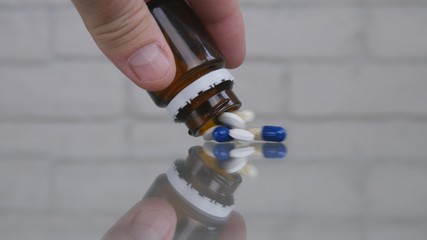 Man Select and Take Pills for a Medical Treatment from the Table