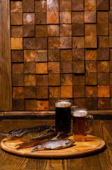 Beer glass with beer on a background of dried fish on a wooden table in a rustic style.