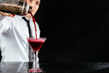 Bartender making a red martini cocktail. 