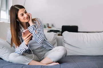 Fototapeta premium Girl at home listening music. Beautiful young woman listening to music indoors.