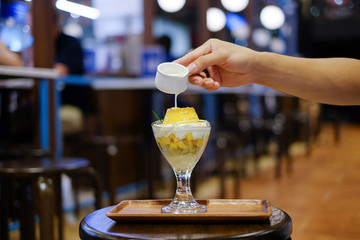 pouring coconut milk over pudding  in summer time , dessert , sweet dessert summer , mango 