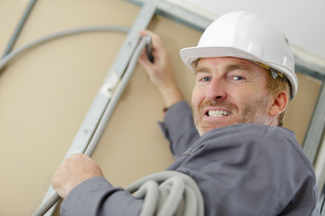 happy builder holding clipboard while working indoors
