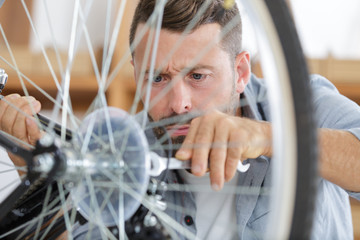 master fixing cogwheel of bike during working day