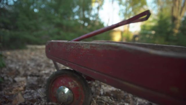 Close up of the rotten and broken wood on an old damaged child's red wagon