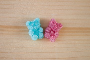 Fototapeta na wymiar Pink and blue jelly gummy bear on wooden background. Polaroid photo.Pink and blue gummy bear in sugar. Friendship symbol, girl and boy.