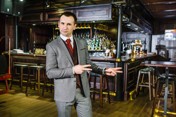 charismatic businessman in a smart suit against the backdrop of a pub