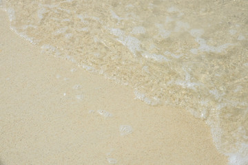 Fototapeta na wymiar Sea water wave and water foam on beach background