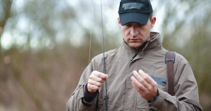 Confident Man Preparing Fishing Rod At Lakeshore