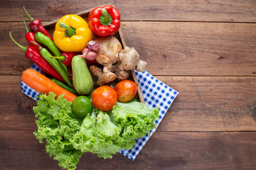 Many kind of vegetable inside and outside wood tray on wood background, for cooking and kitchen concept.