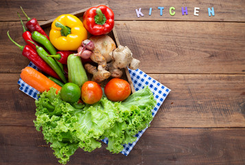 Many kind of vegetable inside and outside wood tray on wood background, for cooking and kitchen concept.