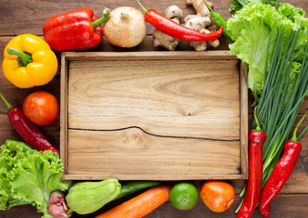 Many kind of vegetable inside and outside wood tray on wood background, for cooking and kitchen concept.