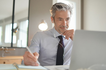 Businessman on video call in contemporary office - Powered by Adobe