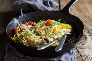 Spaghetti with mushrooms and tomatoes in a pan