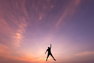 Silhouette of jumping man on sunrise background