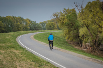 Obraz premium Guy on bicycle exercising on bike rout, rural background