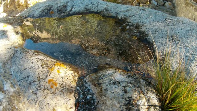 reflection of mountains Himalaya and sky in puddle on rock
