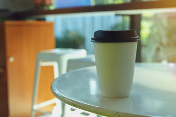 take away cup for hot coffee drink put on wooden table in cafe